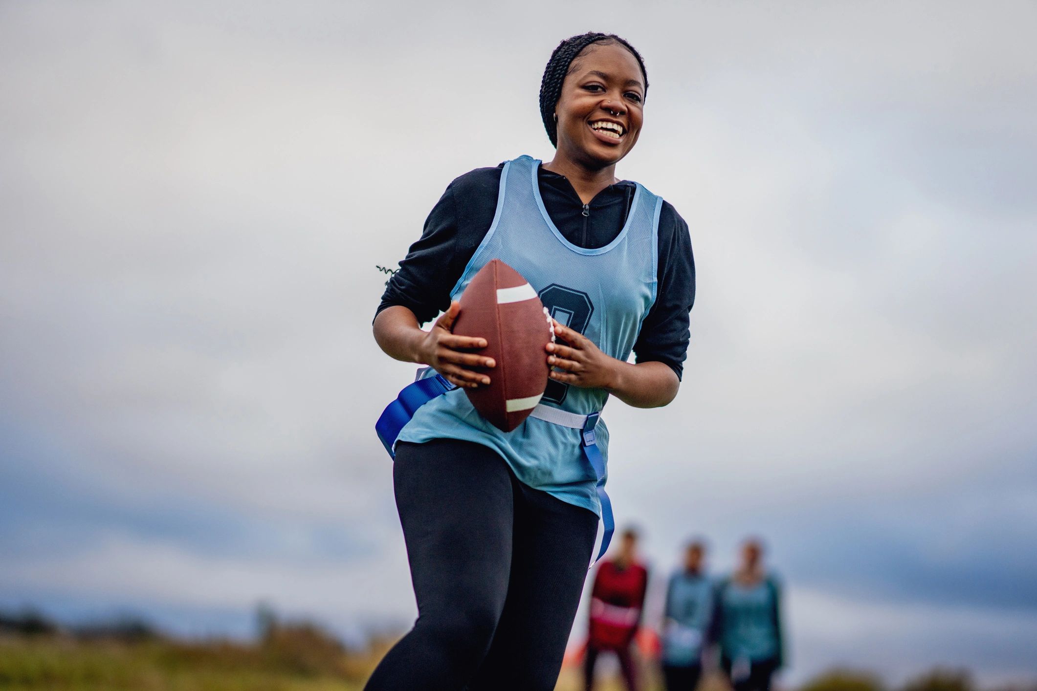 Podcast host with microphone and girls flag football gear